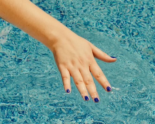 hand on the surface of pool water