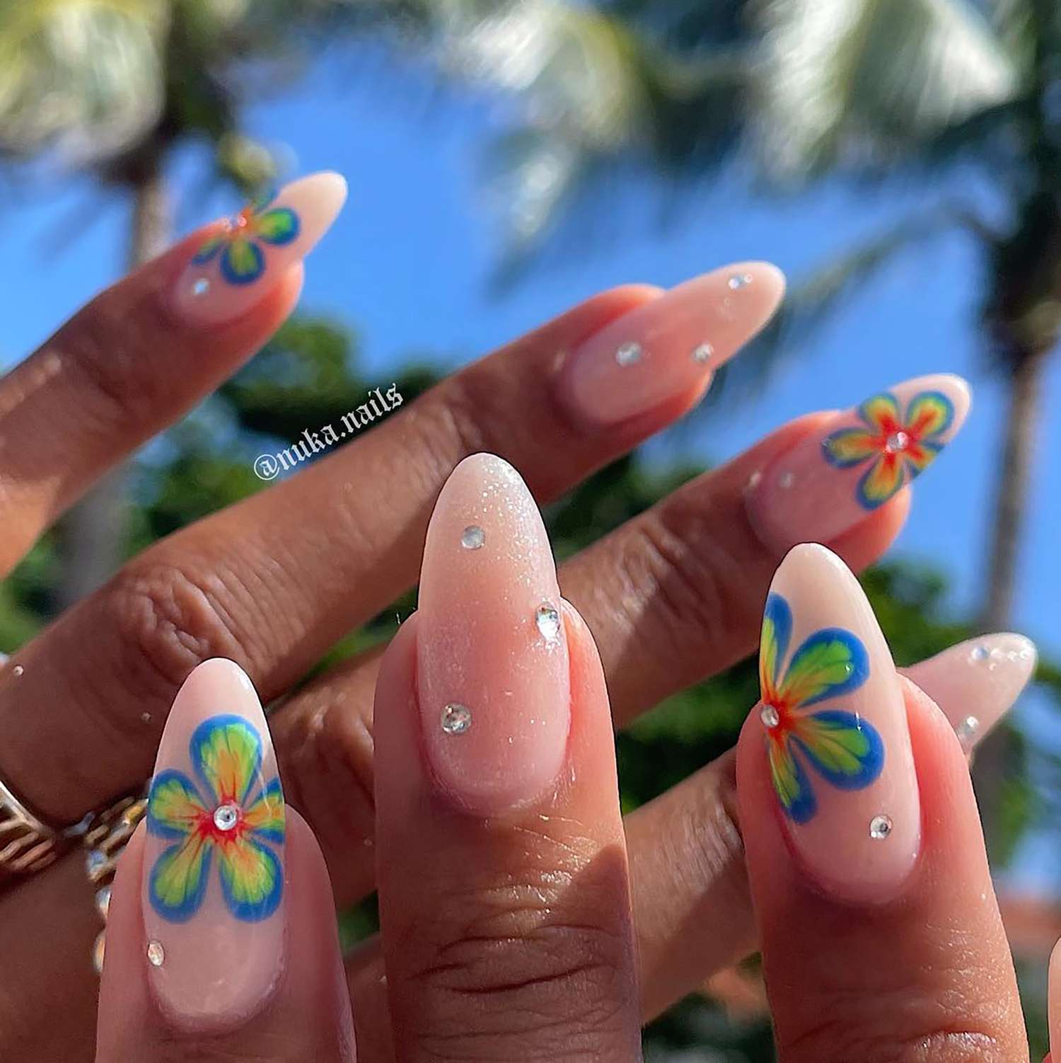 A nude manicure with tie-dye flower nail art