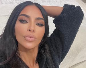 Kim Kardashian wears a neutral rosy-toned makeup look with matte skin and nude lipstick