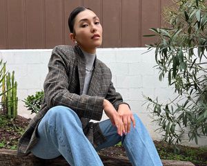 Woman wearing a blazer, turtleneck, jeans, and hoop earrings