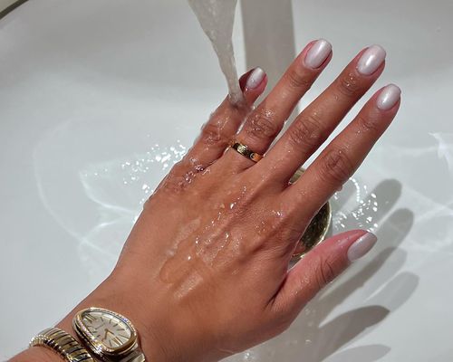 Close up of a hand in the skin under running water, with polished fingers