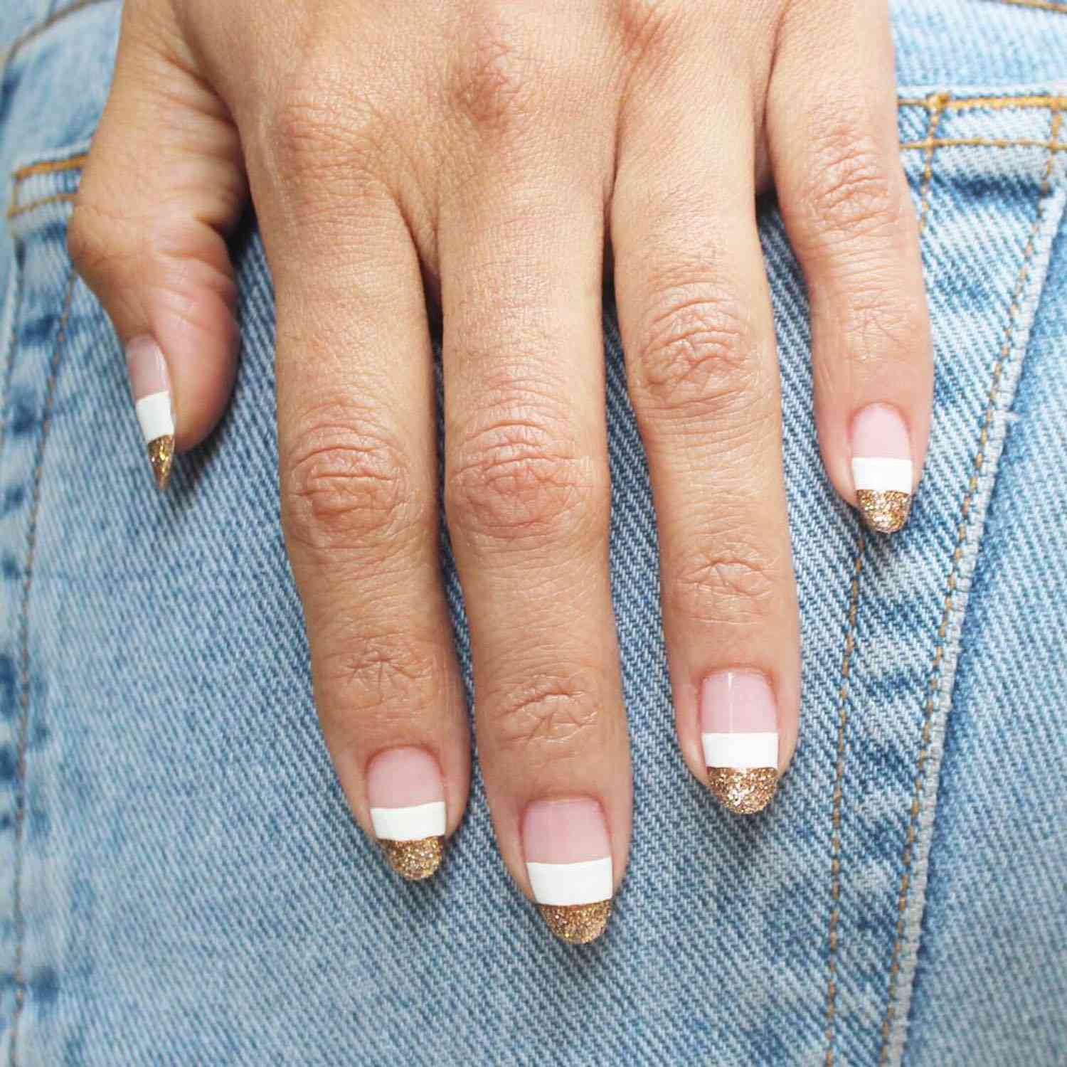 Color block manicure with rose gold tips, white center, and negative space base