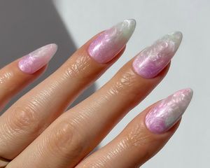 Close up of a swirly pearlescent manicure in light, dainty shades