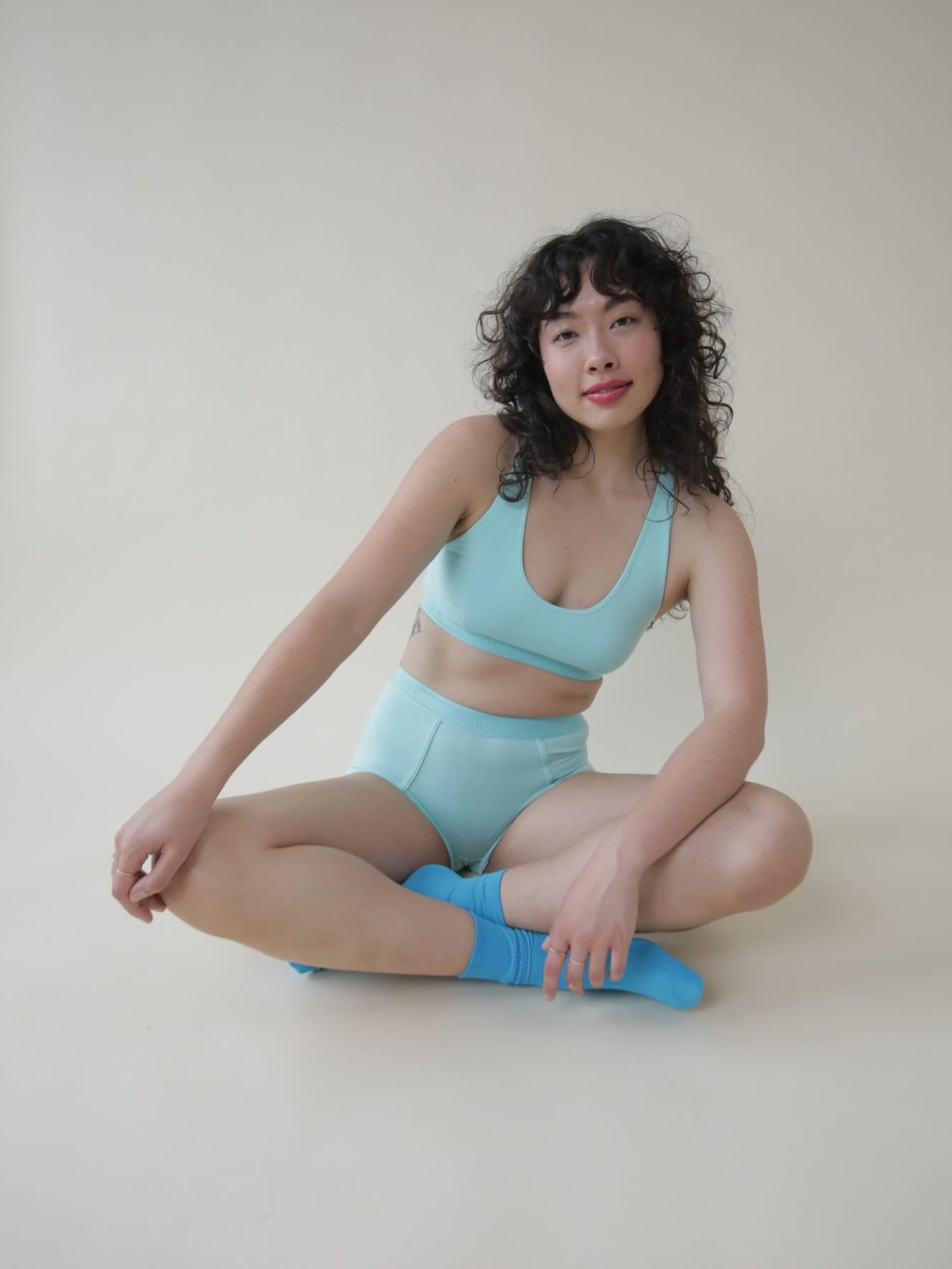 Model wearing light blue sports bra and underwear briefs with sky blue socks