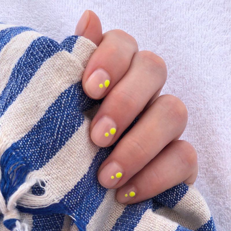 Short nude nails with two neon yellow dots on each nail