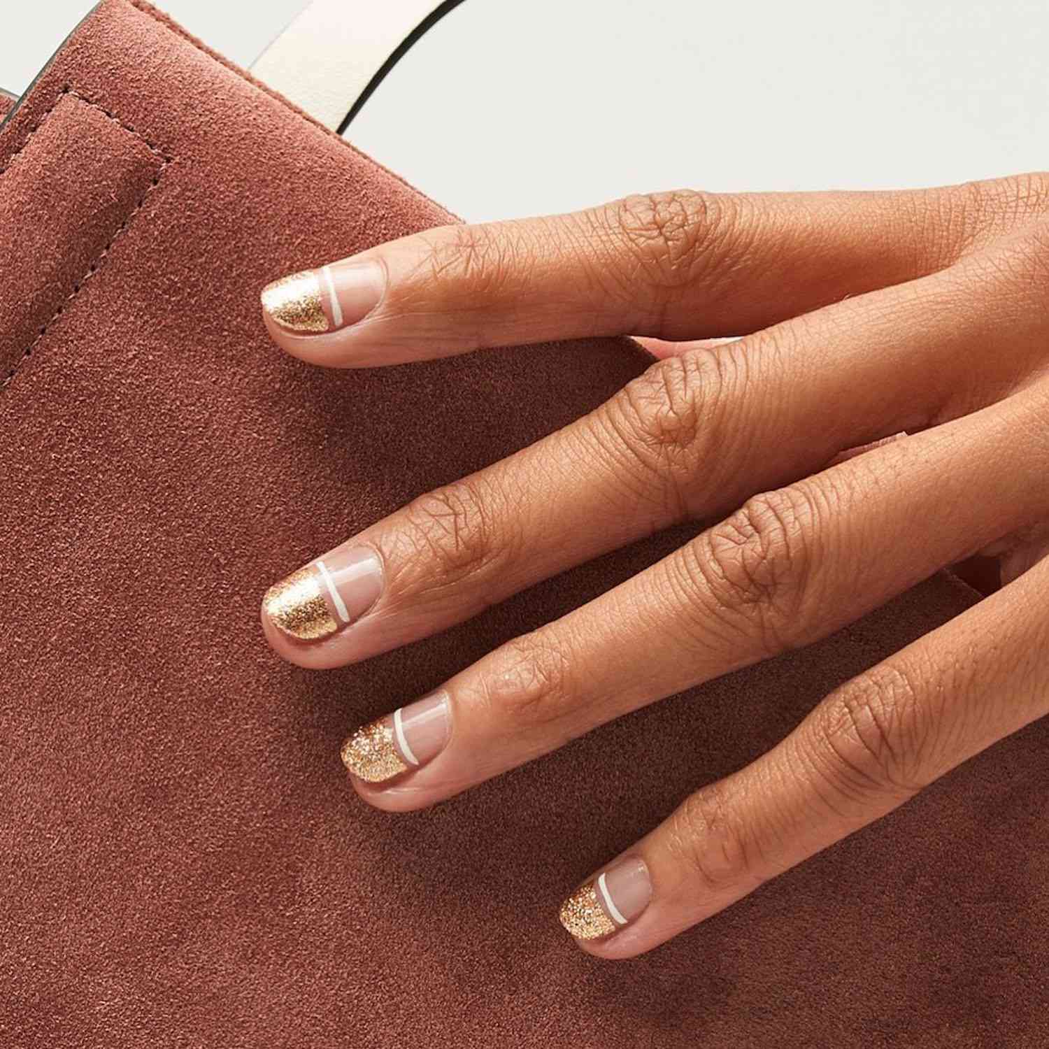 Manicure with rose gold top half and white horizontal central stripe