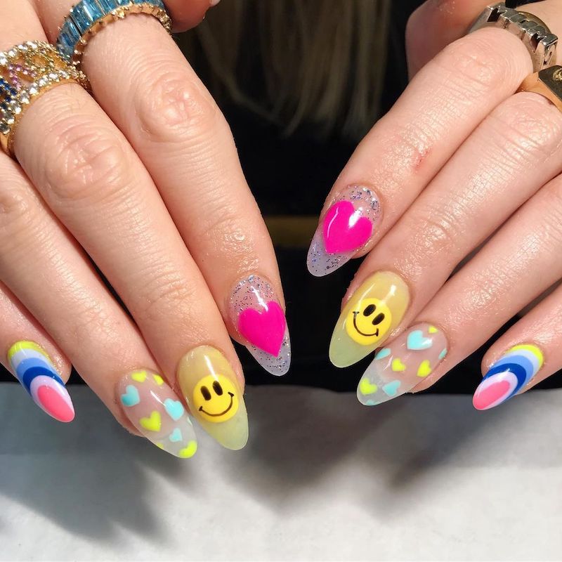 Sheer acrylic nails with neon hearts and emojis