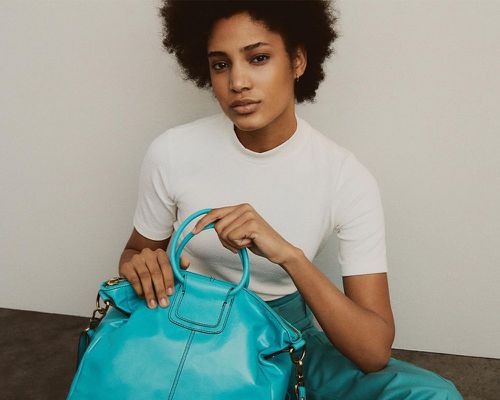 Woman holding a blue Hobo bag