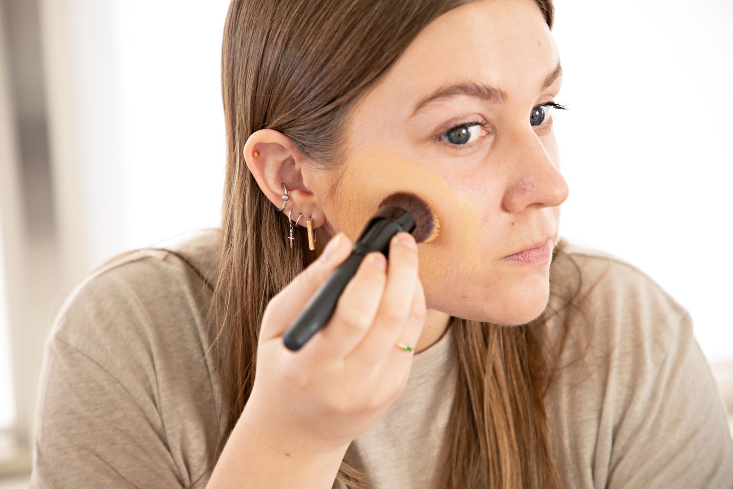 Woman using bareMinerals Smoothing Foundation Brush on cheek