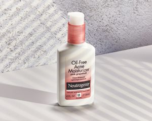 Neutrogena Pink Grapefruit Oil-Free Acne Moisturizer displayed on counter with a grey background