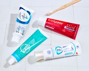 Best whitening toothpastes arranged with a toothbrush on a white tiled surface