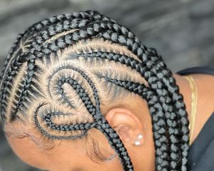 Close up of a heart braided into the side of a woman's cornrowed hair