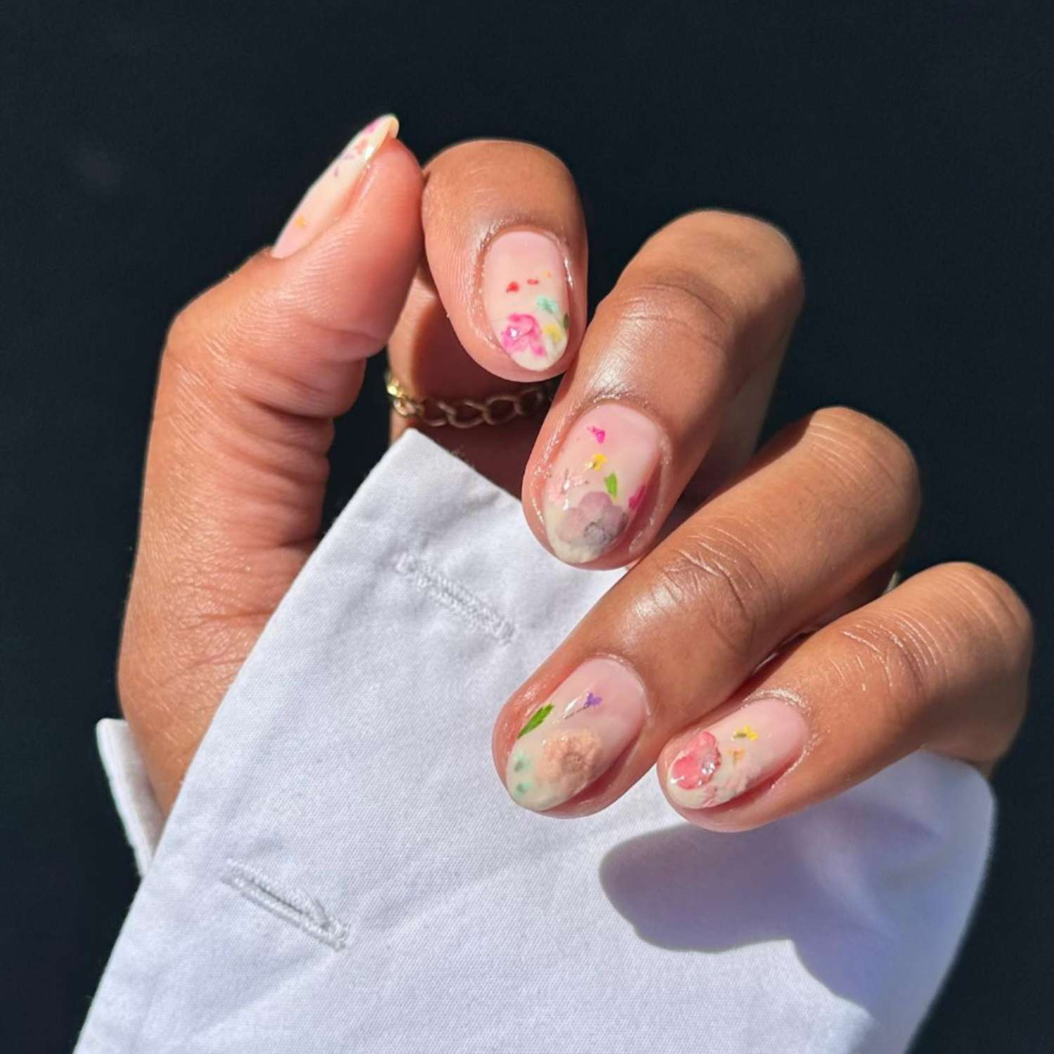 dried flowers pressed in clear nails, viewed up close