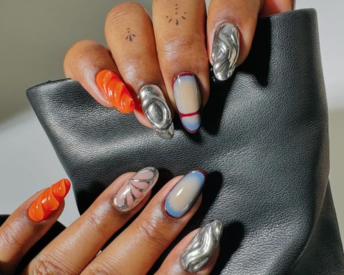 A mismatched manicure with 3D silver chrome, aura and blob details, and more