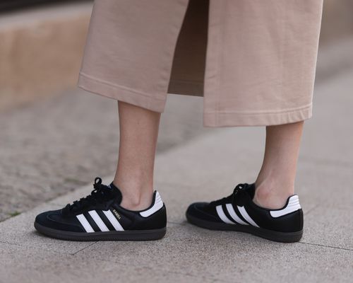 Close-up of black and white Sambas sneakers and rose beige maxi dress