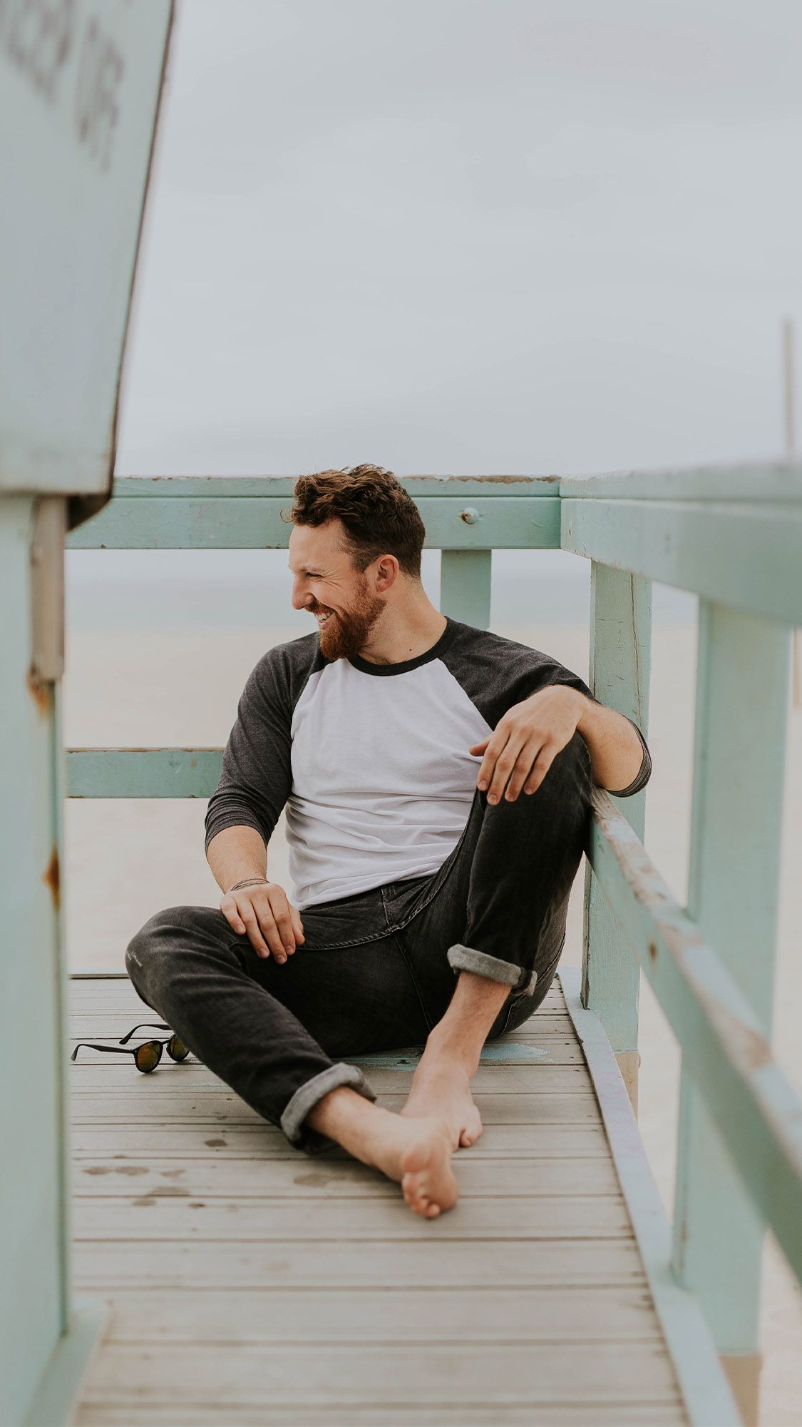 man sitting on beach and smiling