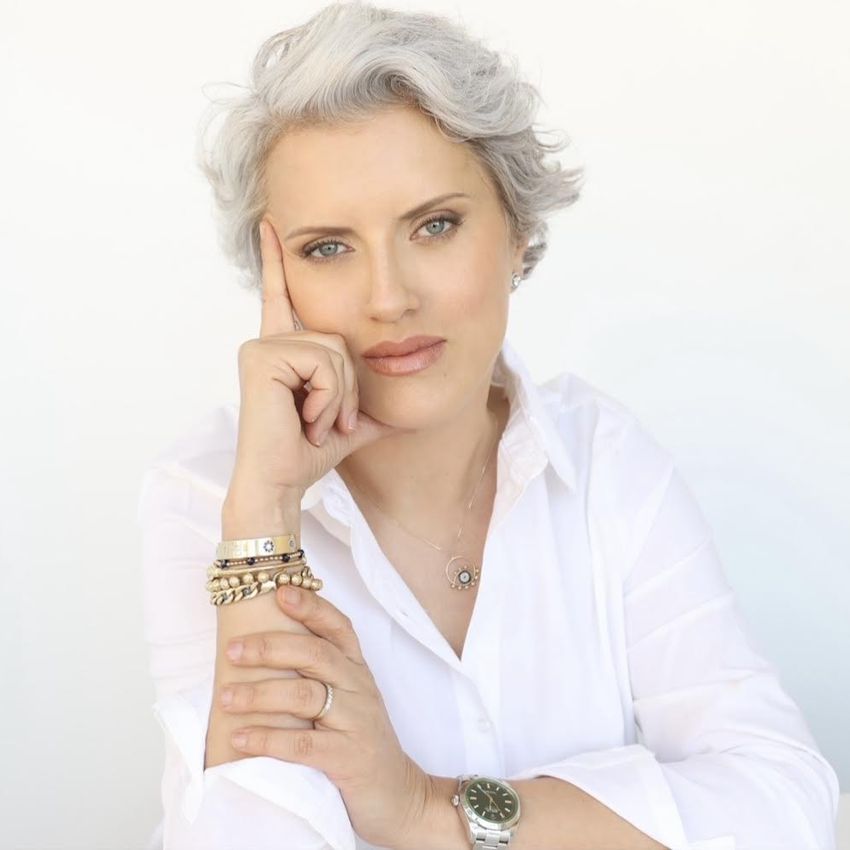 woman wearing white shirt and jewelry posing in front of white background