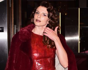 Julia Fox with curly hair, glossy lips and a red leather outfit