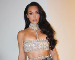 Kim Kardashian with her black hair in a side part and a diamond bandeau top with a faux turtleneck