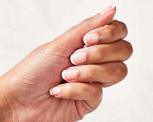 Close up of a woman's hand with a French manicure.