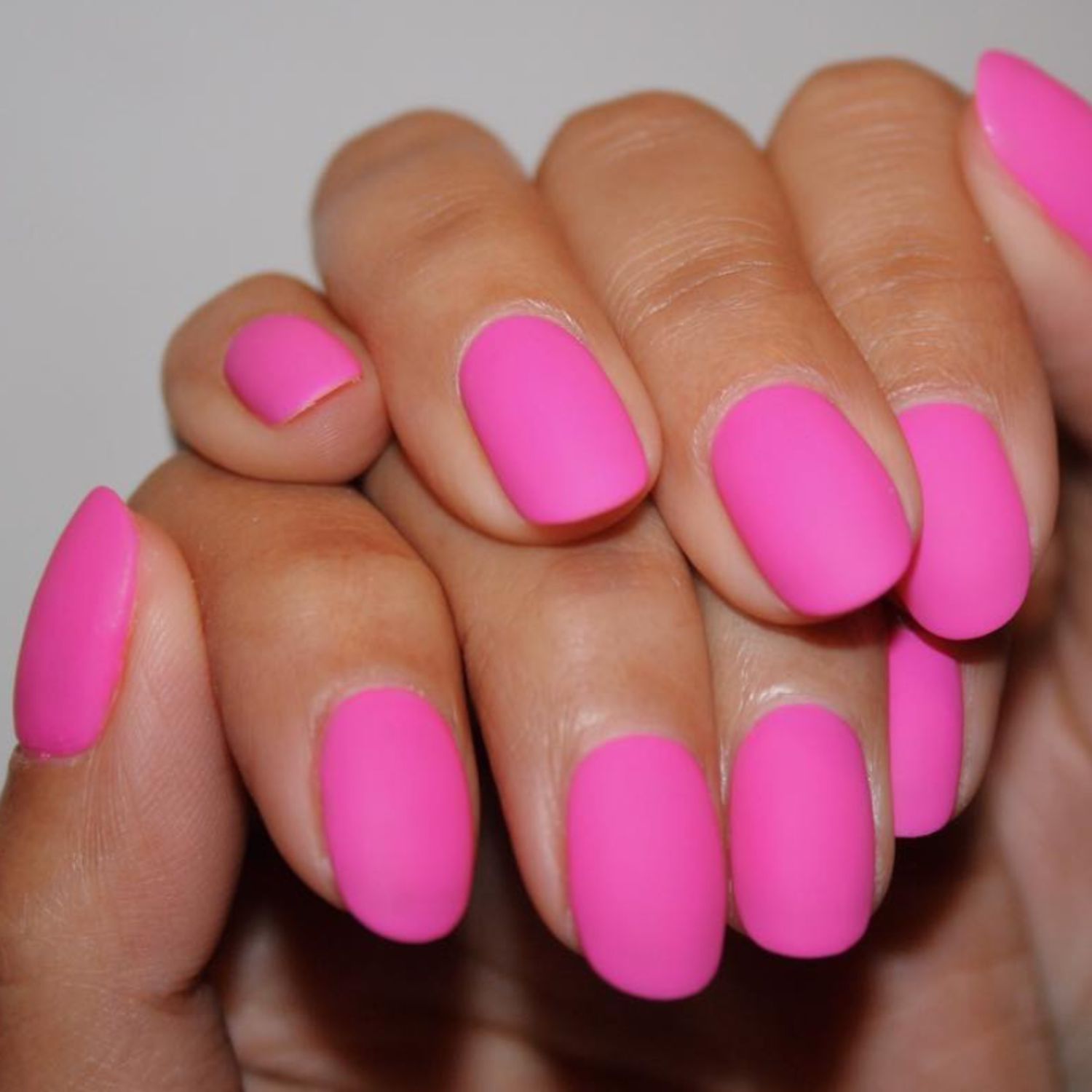 Matte neon pink manicure close up