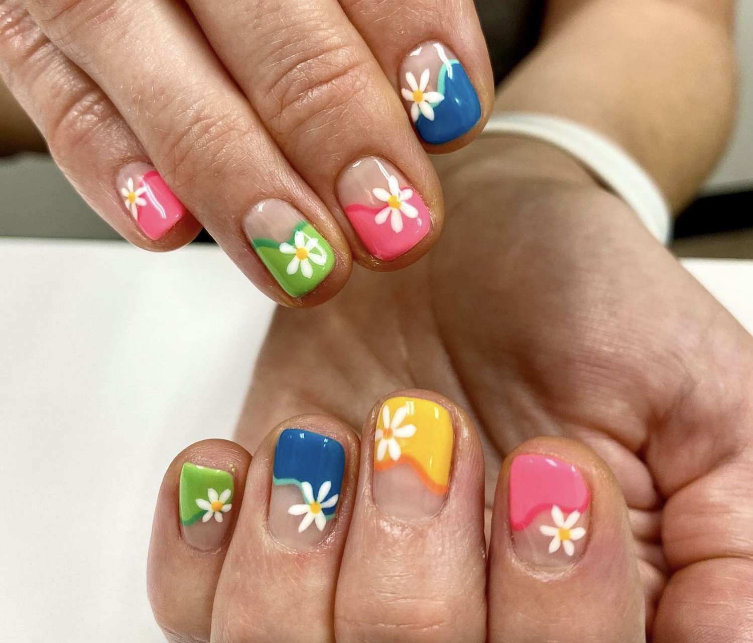 Neon rainbow half-moon manicure with floral nail art