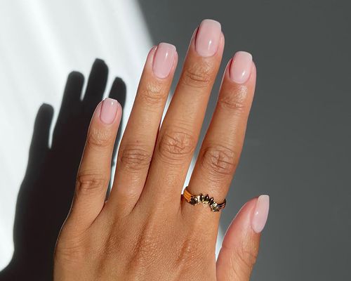 Close up of a manicure in a neutral polish, with square tips