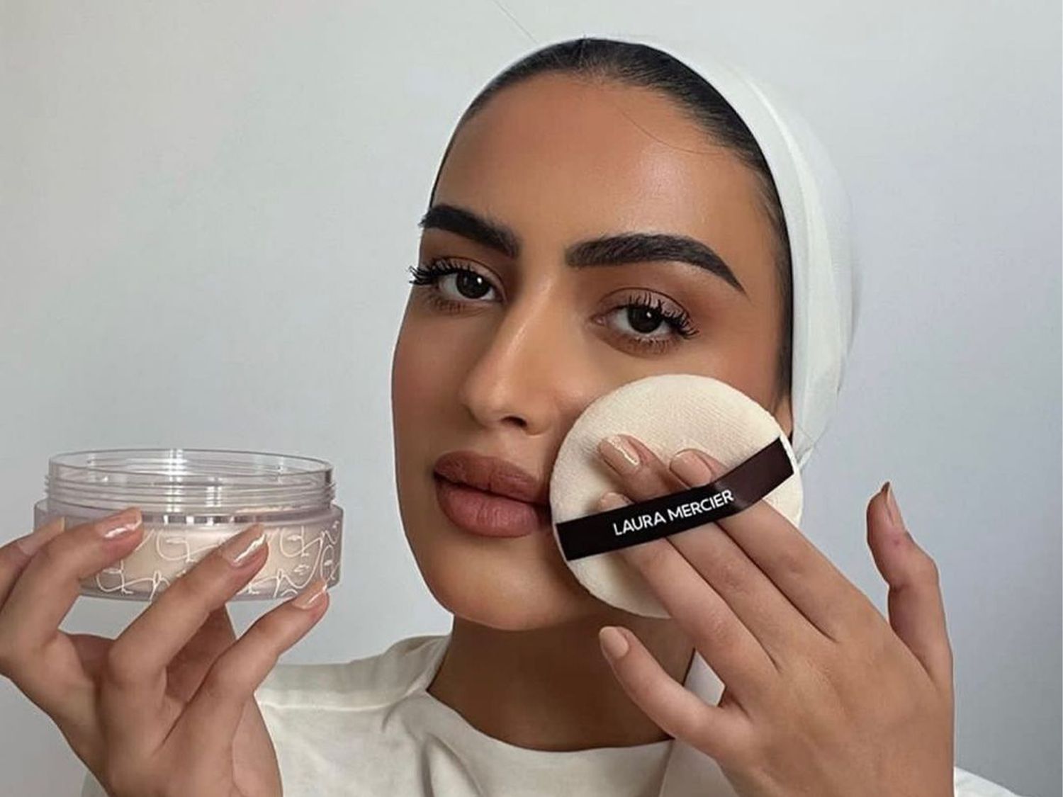 woman using powder puff on her face