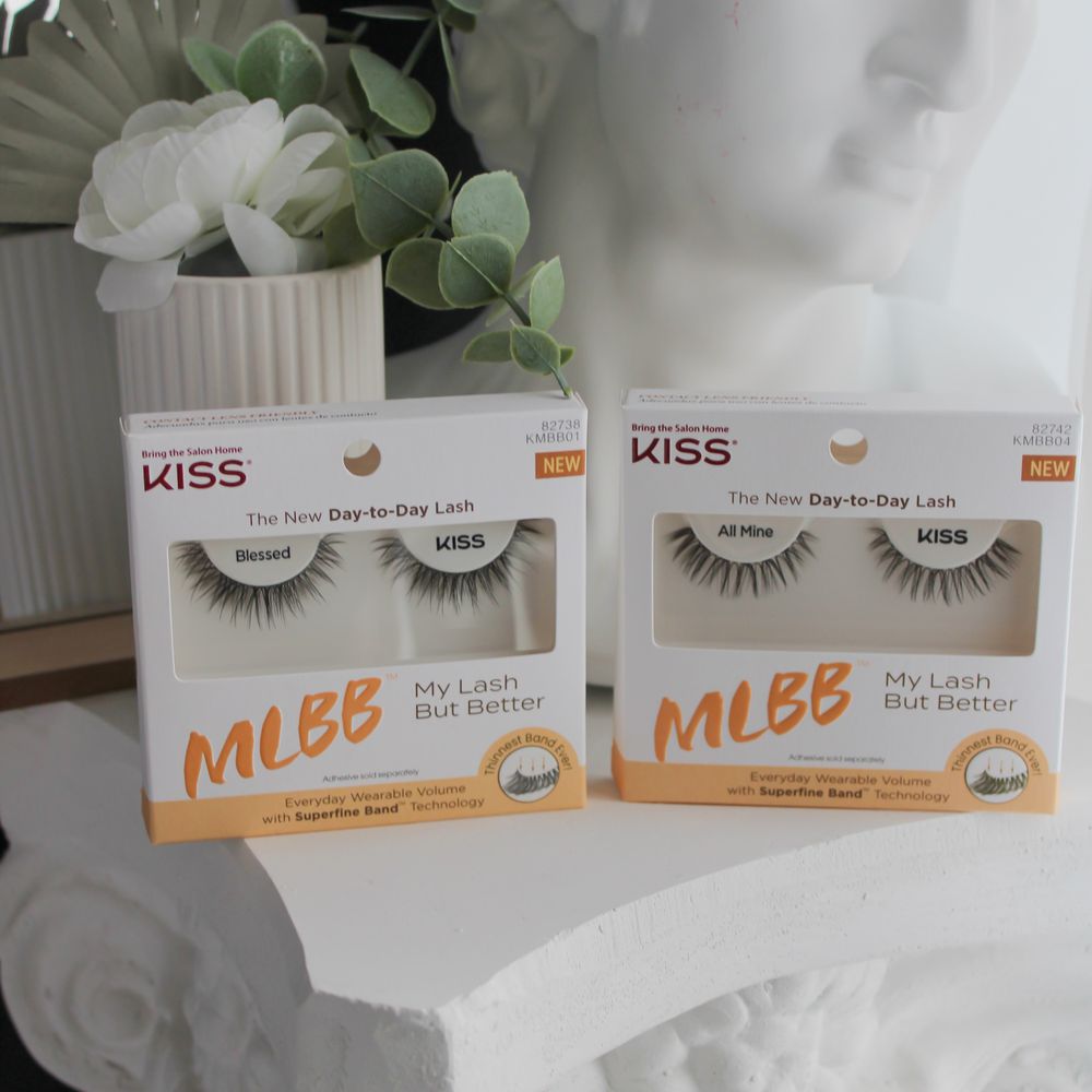 Two sets of Kiss My Lash But Better false lashes in packaging on table