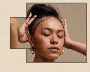 Up close of a woman touching her hairline.