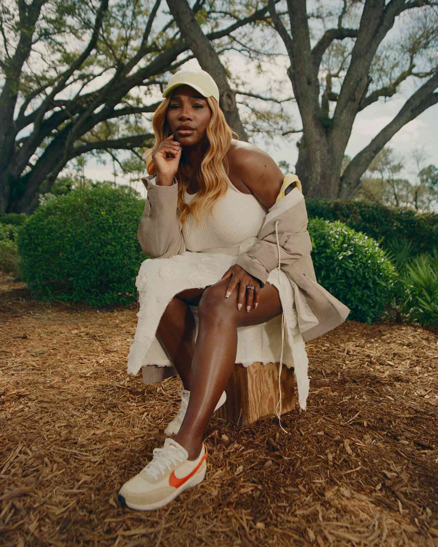 Serena Williams Sitting in a White Floral Skirt White Tank Top Yellow Baseball Hat