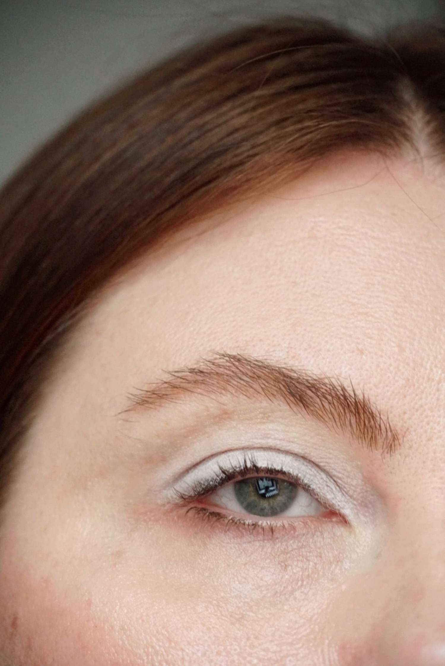 model is posing with eyelid covered in white shadow