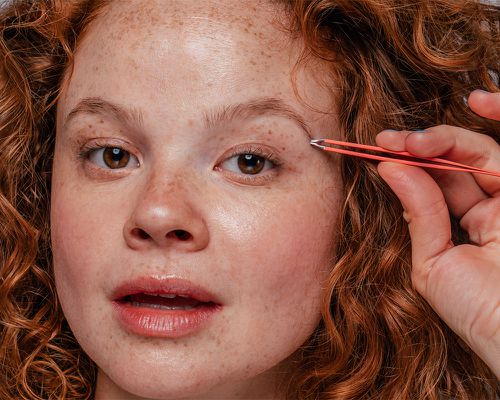 woman plucking eyebrows