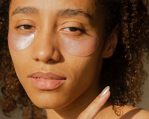 Close-up of a young woman with patches under her eyes