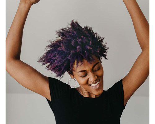 person with purple hair dancing happy