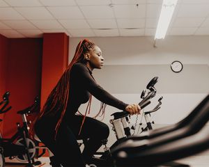 black femme using spin bike cycling