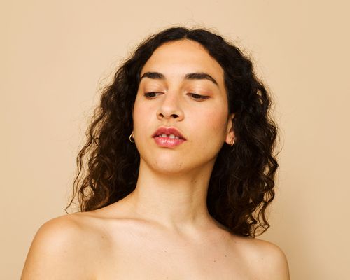 woman with curly hair looking downward