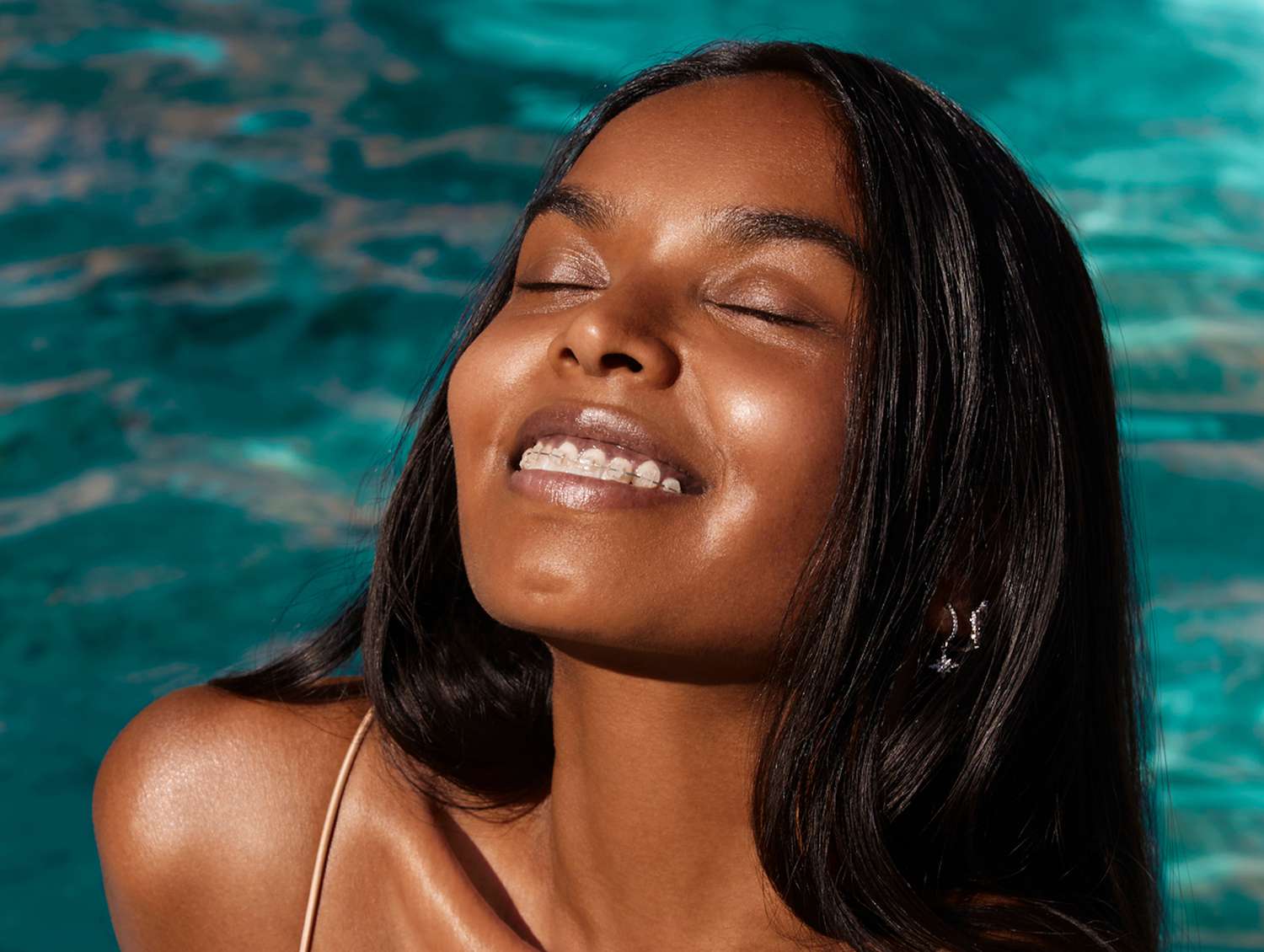 woman smiling with braces in a pool