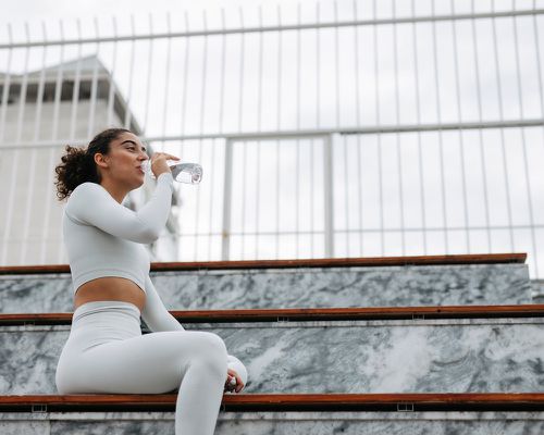 woman drinking water after workout