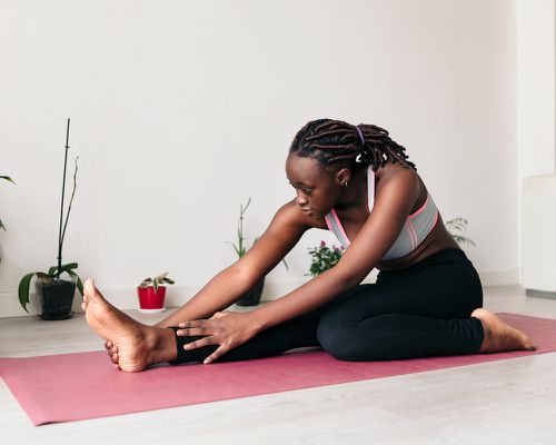 woman stretching on yoga mat