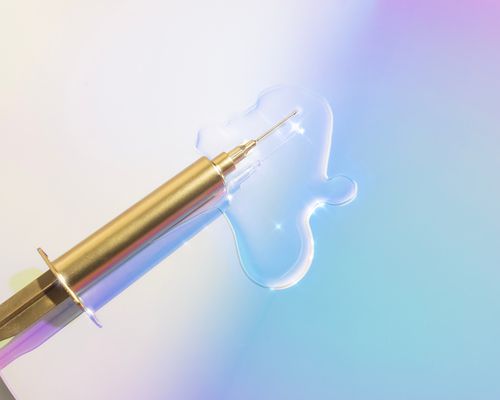 Close up of a syringe on a pastel background