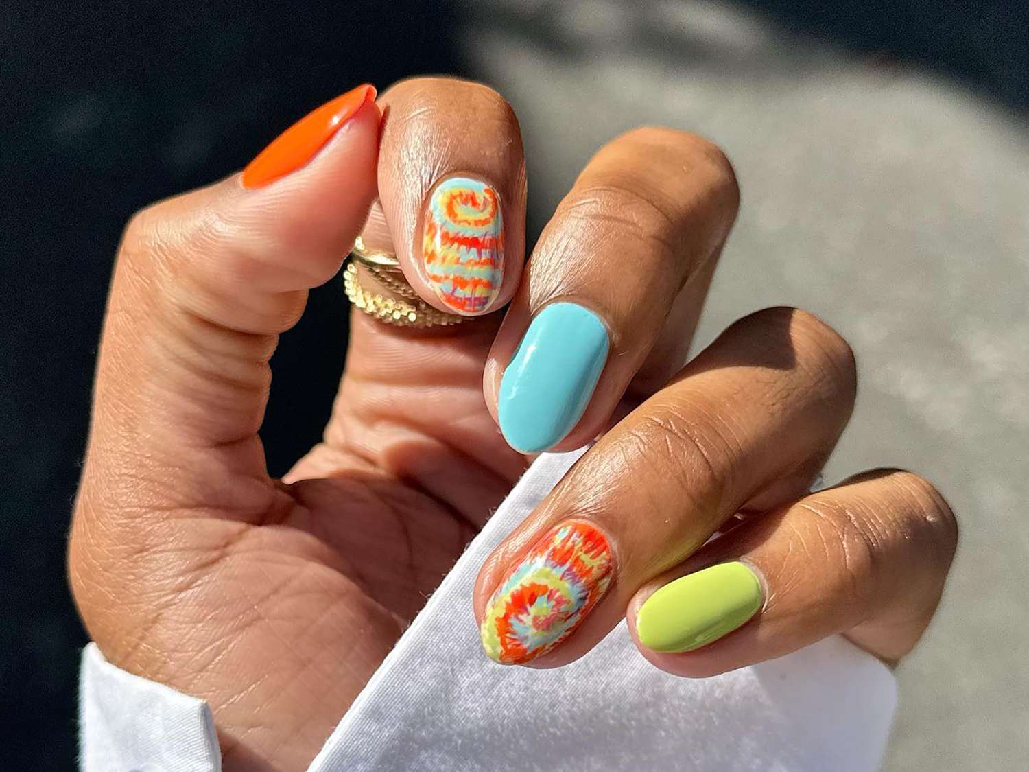 A manicure with three solid fingers and two tie-dye accent nails