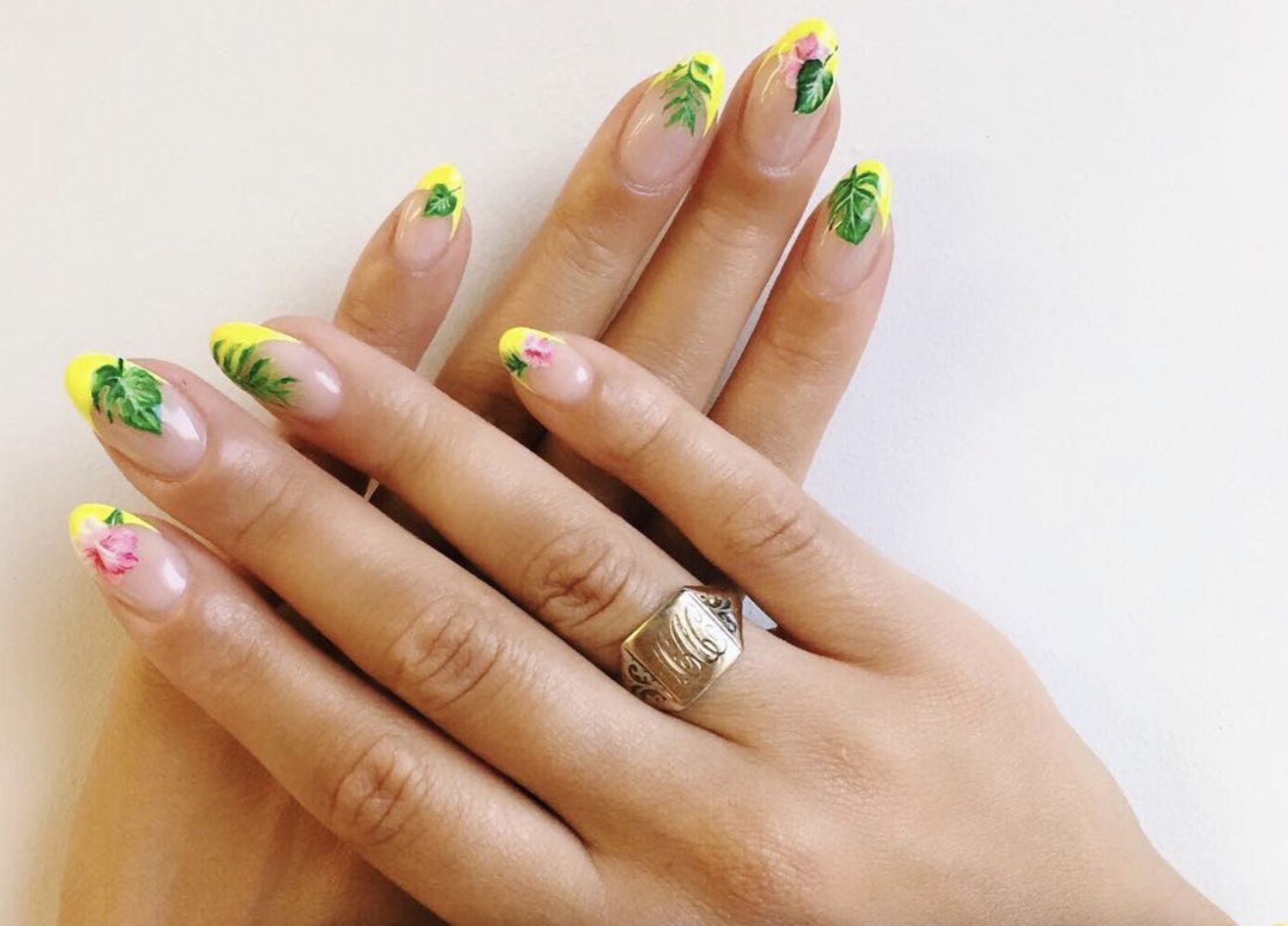 Almond-shaped nails with neon yellow tips and tropical floral motif