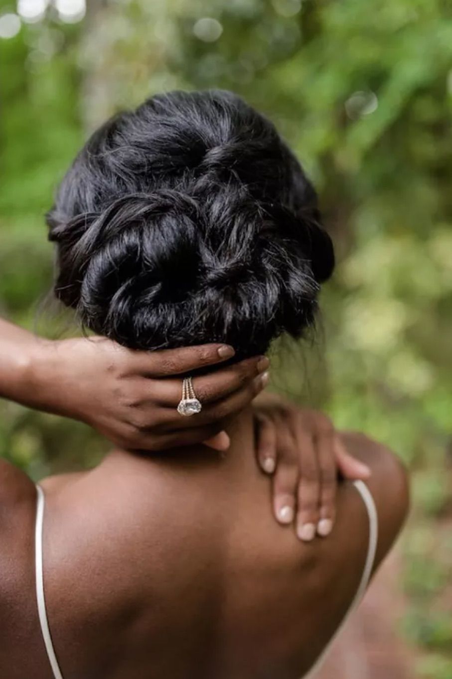 Bride showing off ring and updo