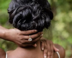 Bride showing off ring and updo