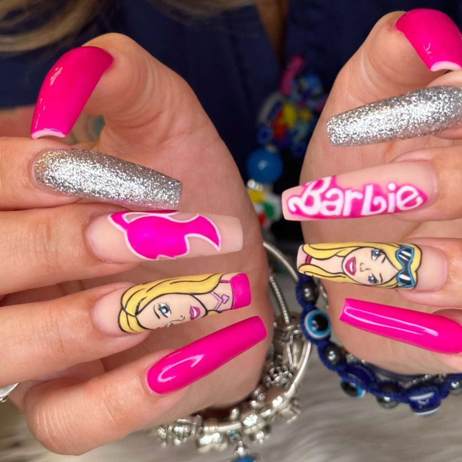 Manicure with hot pink nails, silver sparkle, Barbie logo and silhouette, and Barbie designs