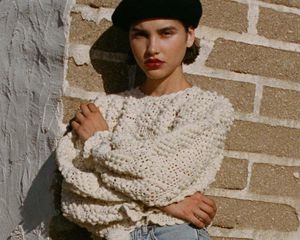 Model wearing white sweater by Doen