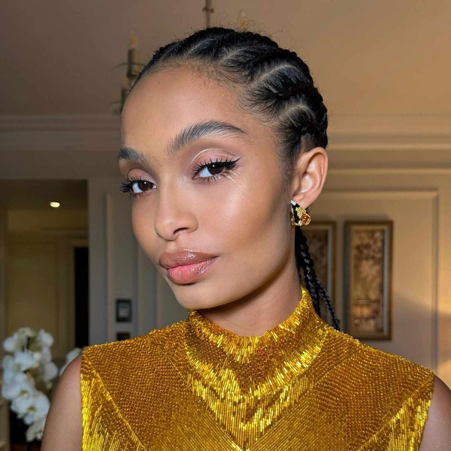 Yara Shahidi with lip gloss, full brows, and winged liner with gold details