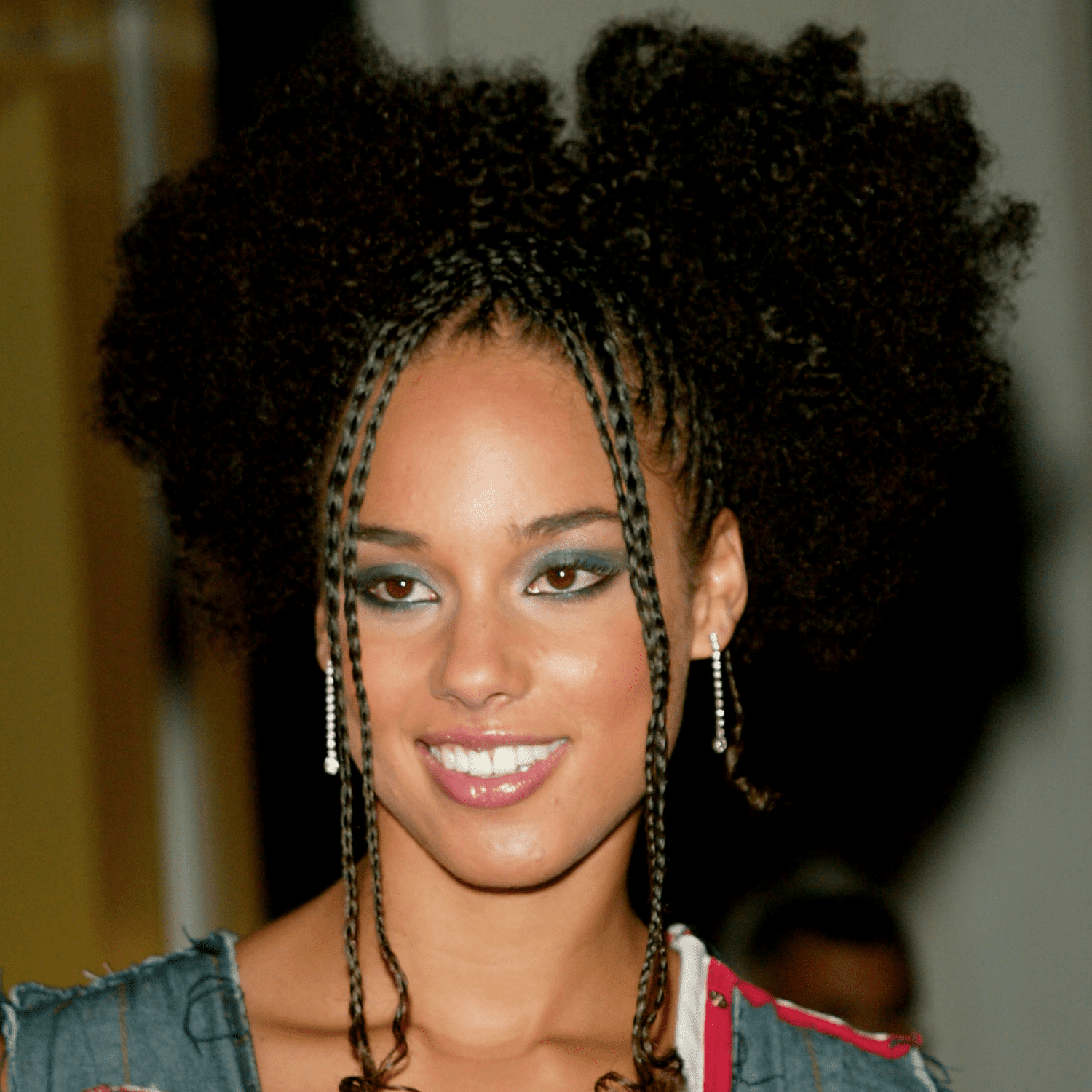 Alicia Keys with afro puffs and her hair cornrowed in the front