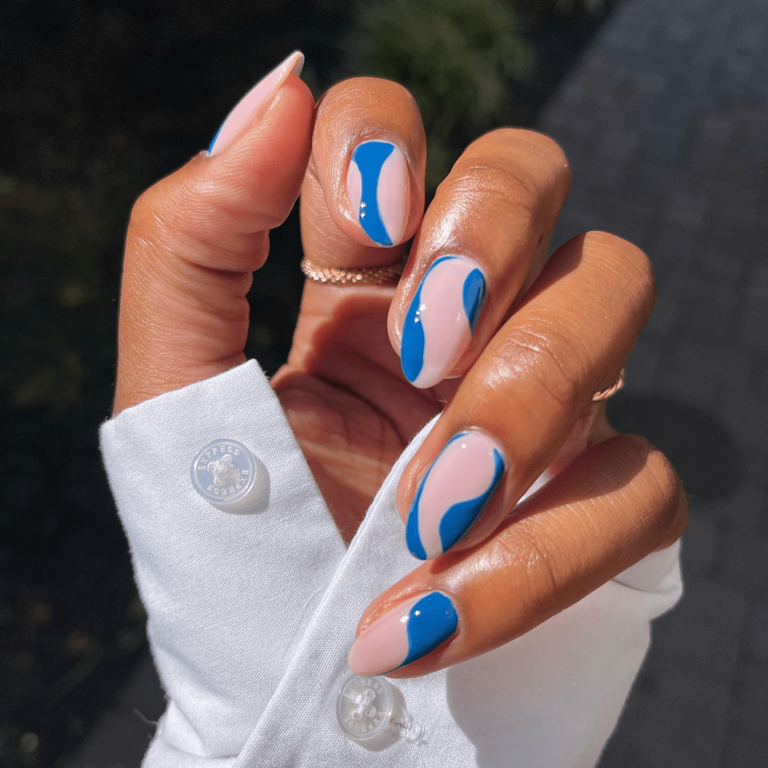 wavy blue negative space nails design with nude pink base